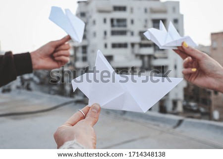 Origami birds of paper in the hands of people