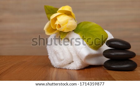 Roll of white towels on table, yellow flower -  with copy space. Spa background stock photo - baners. 