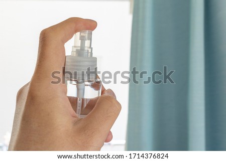 Men disinfect window curtains with alcohol spray Royalty-Free Stock Photo #1714376824
