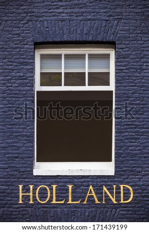 Window of an Amsterdam canal house with the bronze letters "Holland" beneath it
