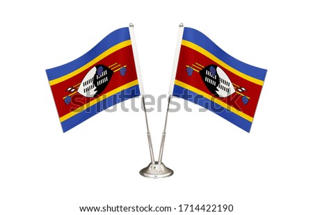 Swaziland table flag isolated on white ground. Two flag poles with flags and Swaziland flag on the table.