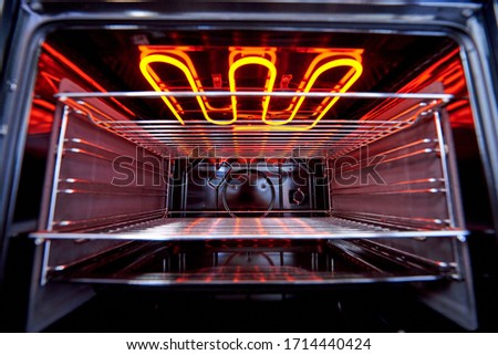 Empty hot oven with a flaming grill close-up. Royalty-Free Stock Photo #1714440424