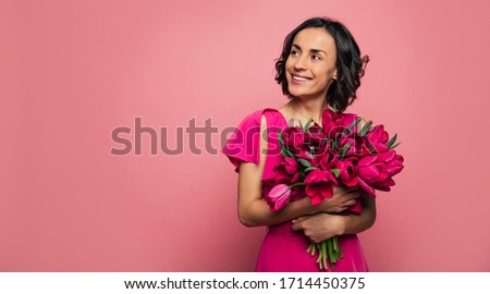 Wedding anniversary. Close-up photo of a stunning woman in a new dress, who is holding a bunch of flowers, celebrating her wedding anniversary.