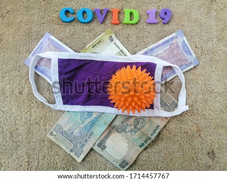 Surgical face mask on Indian rupee bill banknote. Global novel coronavirus (Covid-19) outbreak effect to world economy, financial crisis, investment, stock market. Covid-19 spread to India.
