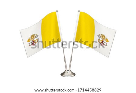 Vatican City table flag isolated on white ground. Two flag poles with flags and Vatican City flag on the table.