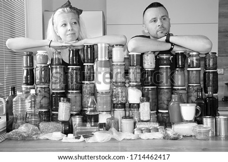 attractive man and young woman witch much food. victuals for eating in corona crisis. stay at home. fear of closed shops