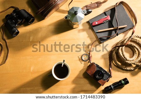 Travel equipment for forest tourism. On the wood floor, / items, including coffee mugs, compass, flashlight, camera, binoculars, knives, ropes, notebooks,