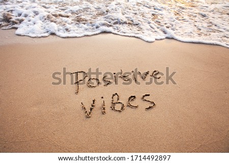positive vibes, text on sand, optimism concept Royalty-Free Stock Photo #1714492897
