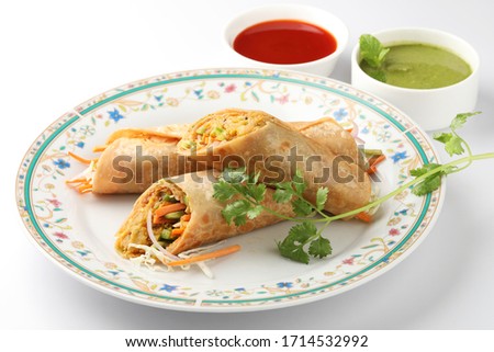 Indian popular snack food called Vegetable spring rolls or veg roll or veg franky made using paneer or cottage cheese and vegetables wrapped inside paratha/chapati/roti with tomato ketchup.
