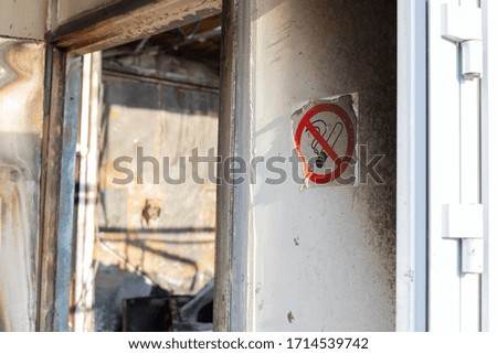 No smoking sign on the wall of the room after a fire. charred walls. violation of fire safety rules. side view.