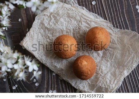 View from above. Cupcakes on paper and on a wooden brown background, composition with white flowers.