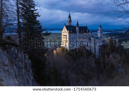 Das wunderschöne Schloss Neuschwanstein in den Bayerischen Alpen bei Füssen im Winter bei Sonnenuntergang in der blauen Stunde