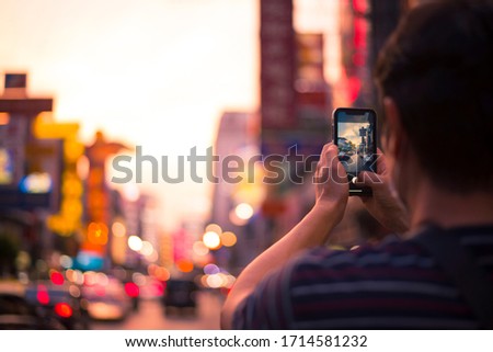 Tourist is taking photo of Chinatown during sunset in Bangkok, Thailand