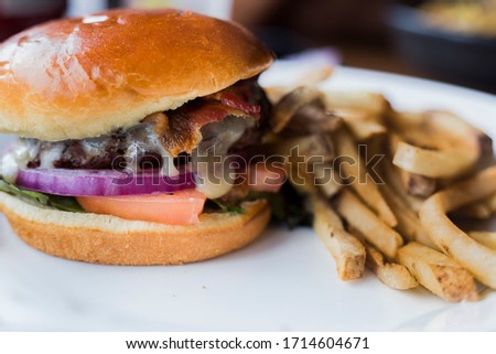 Burger and fries combo looking good on plate close up