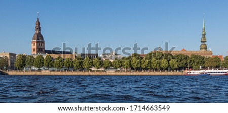 Sightseeings of Riga from the river Daugava. View of the Dome Cathedral, St. Peter's Church and the promenade. Banner