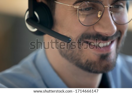 Close up head shot smiling man wearing headset with microphone, friendly call center worker operator consulting client customer, mentor teach holding online lesson, student listening lecture