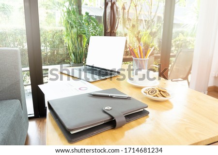 Working home concept - Comfortable workplace with laptop book pencil cookies and cup of tea in the room. Royalty-Free Stock Photo #1714681234