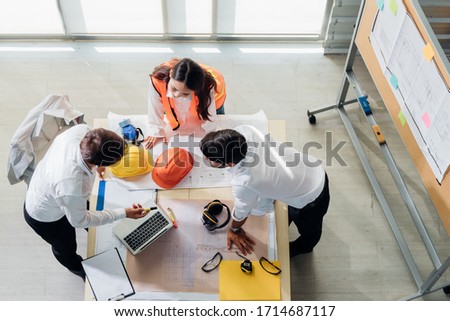 Top view of engineer young asian and caucasian wear safety helmet in new project meeting. Teamwork people engineer consultant entrepreneur casual brainstorm. Industry, Engineer, construction concept. Royalty-Free Stock Photo #1714687117