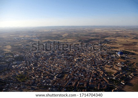 Blue and white Hot Air Balloon flying over a town called Daimiel in Castilla La-Mancha