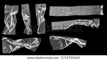 Metallic sticky teared tape shapes isolated on black background. Shiny flexible crumpled glitter holo stickers. Silver metallic stripes, adhesive pieces. Design elements for a poster idea. Royalty-Free Stock Photo #1714705660