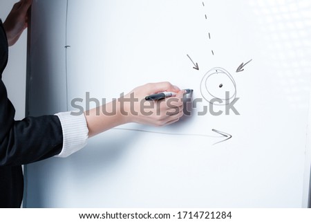 Close-up. female hand draws a business idea and statistics on a white board Success concept through many paths