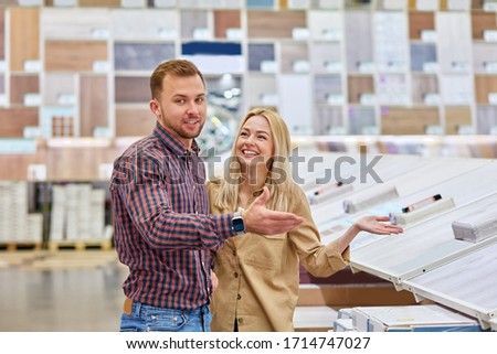 attractive caucasian couple choosing decorative thing for their house, share opinions, talking in the market