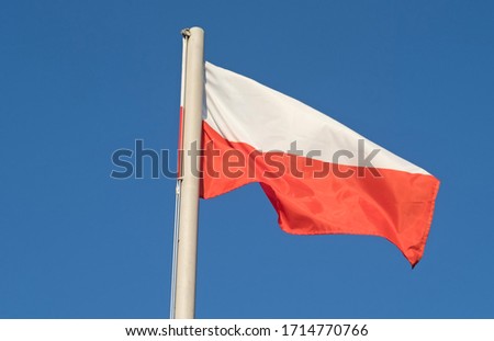 Waving national flag of Poland on a flagpole, national colors of Poland.

