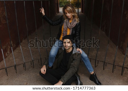 Daring man and woman sitting near the gate