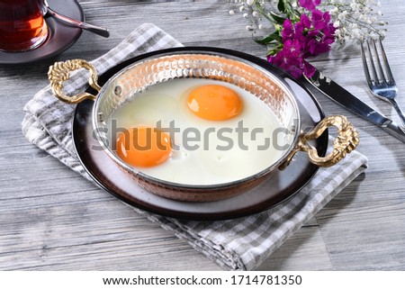 Eye egg cooked in copper pan. with breakfast and tea