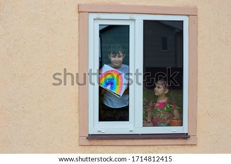 Children from the window show a picture of the rainbow, as a symbol of support during the coronavirus