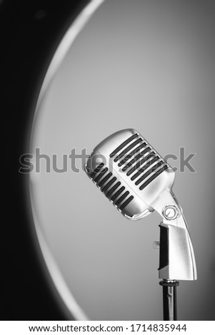 Old style vertical photo of a metallic mic from the side isolated on white background. Vintage silver microphone closeup on white background. Retro oldies music concept. Royalty-Free Stock Photo #1714835944