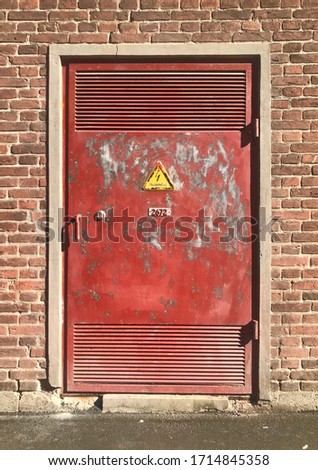 Weathered and rusty red high voltage door