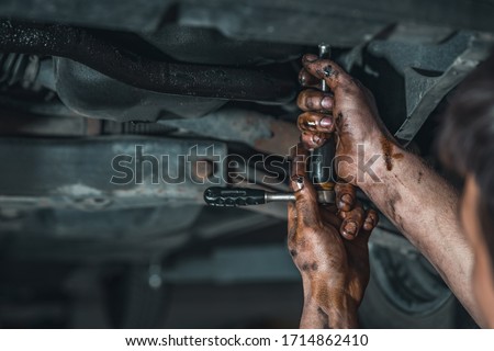dirty hands of a technician while repairing a car Royalty-Free Stock Photo #1714862410