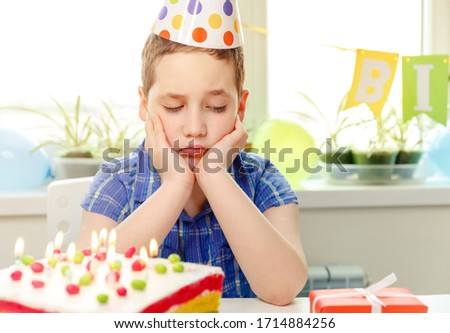 Sad child crying at birthday party. Birthday party alone at home