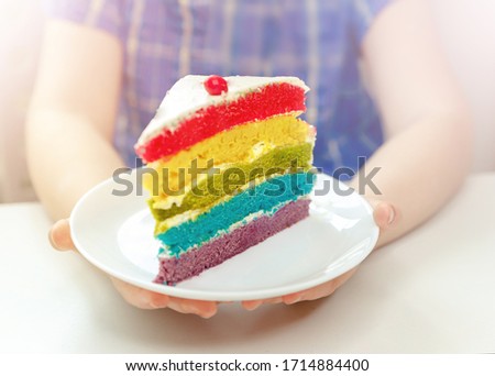 Hands of a child holding a piece of birthday cake. Birthday party 