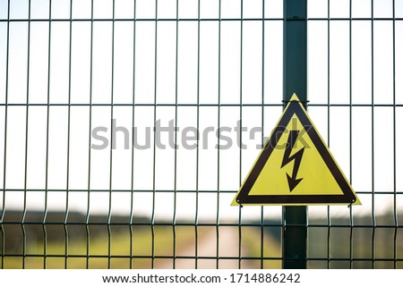 A warning sign about the danger of high voltage hardened in the fenced area, with copy space.