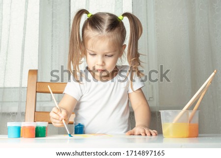 what to do for a child during the period of quarantine and self-isolation, a girl plays and paints with oil