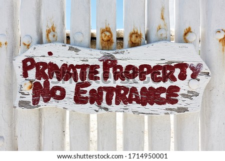 Private property No entrance sign on white wooden fence
