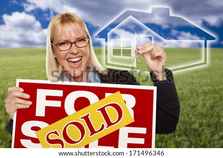 Very Happy Woman with Sold For Sale Real Estate Sign, Keys In Hand and Ghosted House Behind Her.