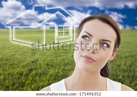 Contemplative Woman in Grass Field Looking Up and Over to the Side with Ghosted House Figure Behind.