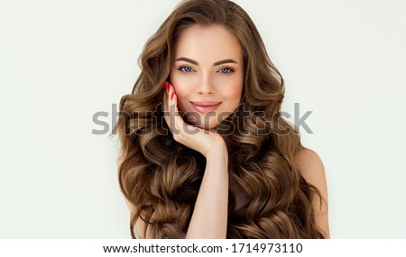 Beautiful laughing brunette model  girl  with long curly  hair . Smiling  woman hairstyle wavy curls . Red  nails manicure .    Fashion , beauty and makeup portrait
 Royalty-Free Stock Photo #1714973110