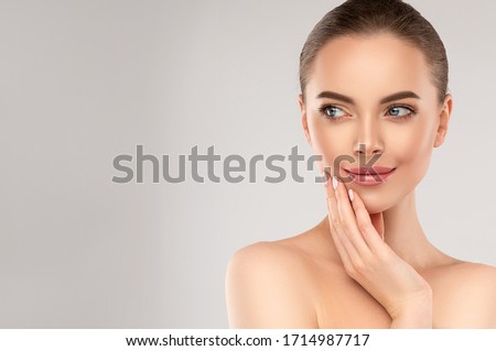 Beautiful young woman with clean fresh skin on face . Girl facial  treatment   . Cosmetology , beauty  and spa . Royalty-Free Stock Photo #1714987717