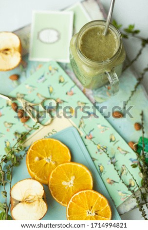 Photo of a full Breakfast with smkzi of fruits and greens. The photo shows greens and fruit slices. The colors of the bed are light. The mood in the photo is morning, Sunny. The view from the top.