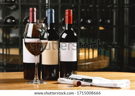 Bottles and glasses with wine on the table. Wine drinking culture concept. Apperetes and survivors. Copy space, dark background Royalty-Free Stock Photo #1715008666