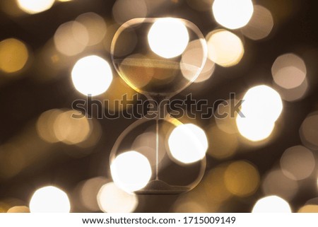 Hourglass on a background of blurry city lights, abstract photo.