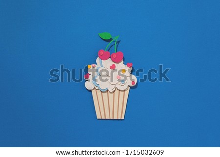 Paper cutting cupcake on blue background. Handmade art work. Colorful sprinkles, dot and star, for your birthday card design. Confetti. 