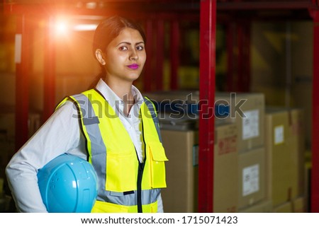 Young latina woman working in the warehouse.