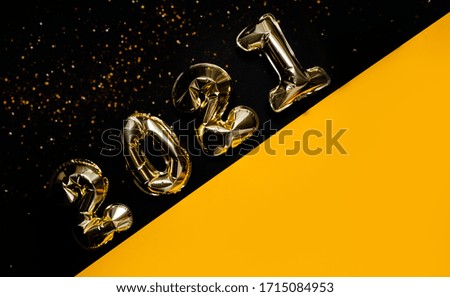 Golden balloons on bright yellow background with bokeh and sparkles. Wishlist  with resolution and new year concept. Top horizontal view background