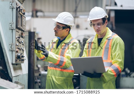 technician engineer and mentor checking process on laptop to automated CNC in factory Royalty-Free Stock Photo #1715088925
