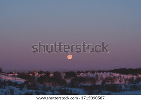 Full moon on a bright purple dawn
